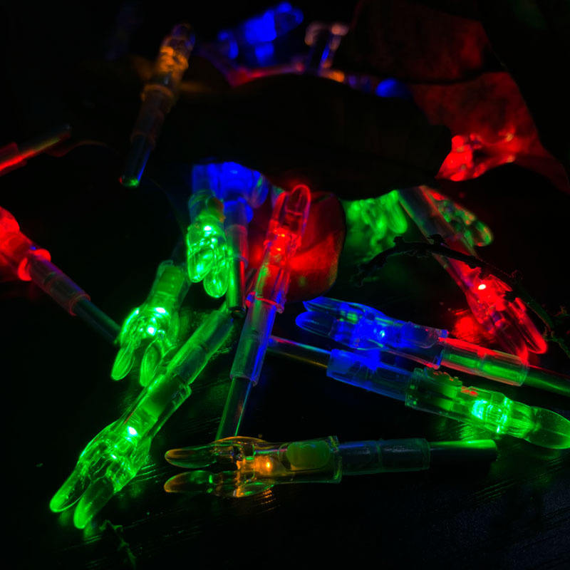 High visibility LED archery nock glowing brightly in low light conditions for arrow retrieval